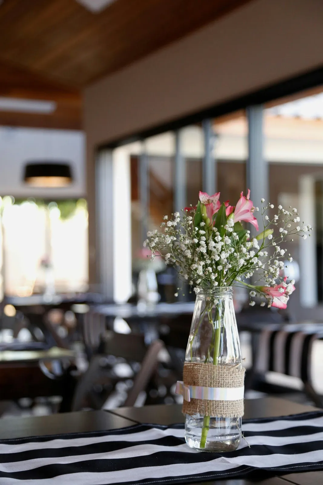 Gypsophila and alstroemeria in a hessian-wrapped bottle vase