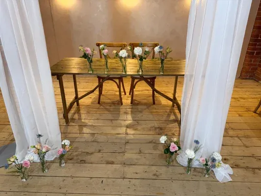 Bud vases of pastel flowers dressing a wedding top table