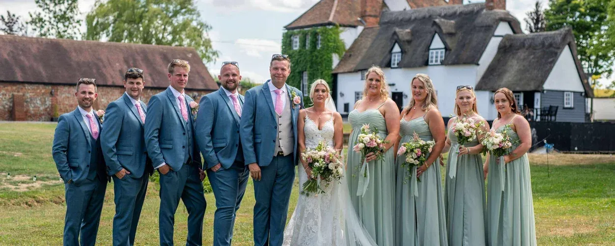 Wedding party with bridesmaids holding blush bouquets